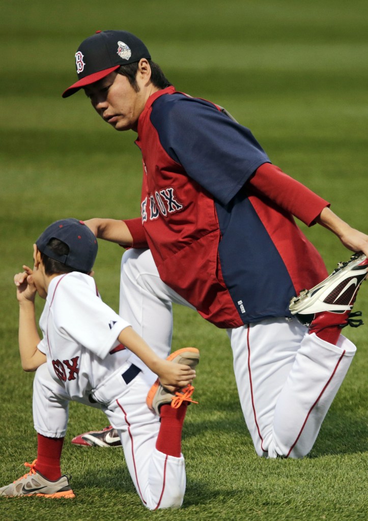 Boston Red Sox closer Koji Uehara stretches with his son Kazuma during a workout out at Fenway Park Tuesday. Uehara, in his first season with Boston, was MVP of the ALCS.