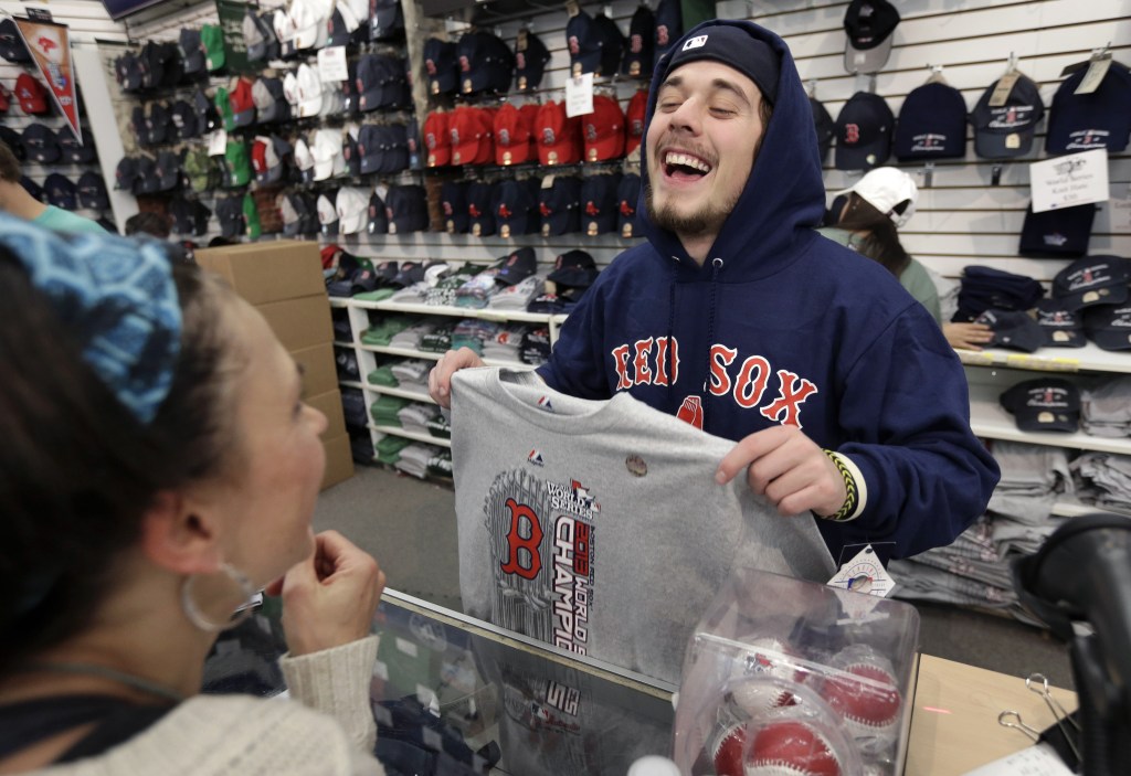 Worker Jake Miskin laughs with Lori Leduc of Calgary, Alberta, Canada as she buys a 2013 World Series champions shirt at a shop near Fenway Park in Boston on Thursday.