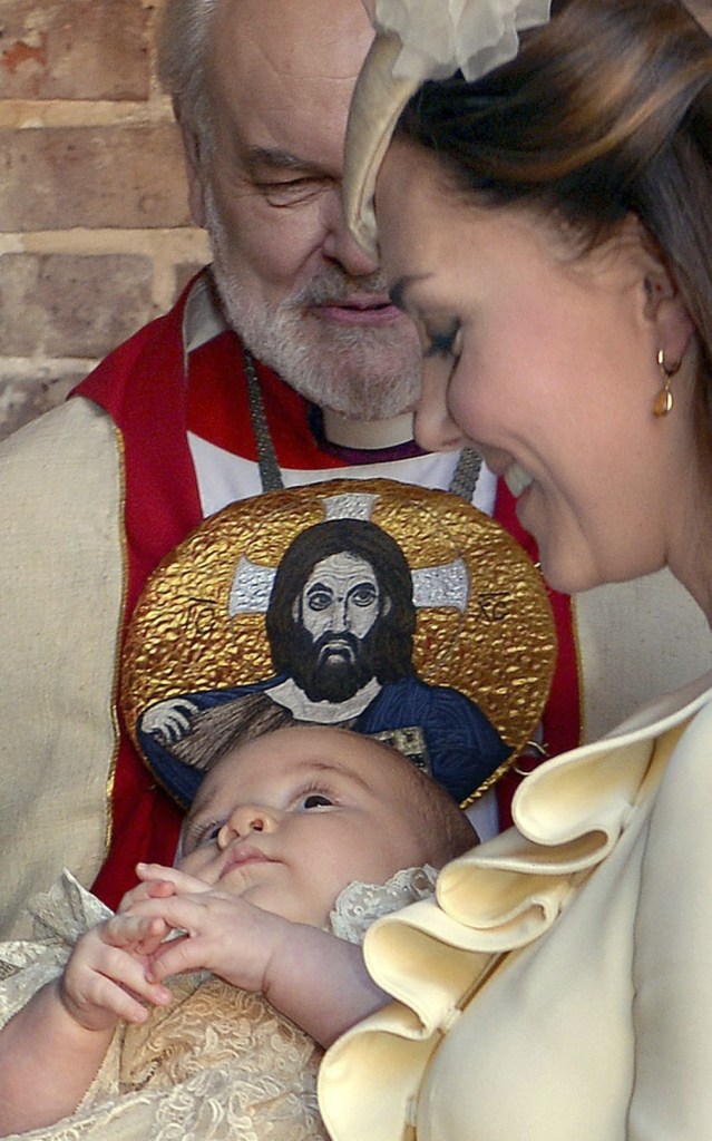 Kate, Duchess of Cambridge, holds Prince George after his christening in London as Bishop of London Richard Chartres looks on.