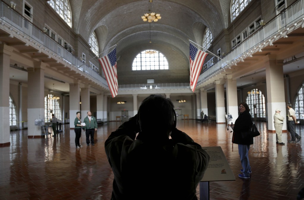 A visitor to the newly re-opened Ellis Island takes a picture of the registry room on Monday. The island that ushered millions of immigrants into the United States received visitors Monday for the first time since Superstorm Sandy flooded its basement.