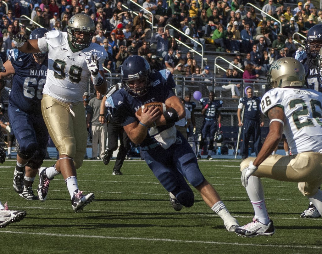 Maine quarterback Marcus Wasilewski carries the ball inside the 5-yard line past William & Mary players Tyler Clayter (99) and Ryan Smith (26) converge.