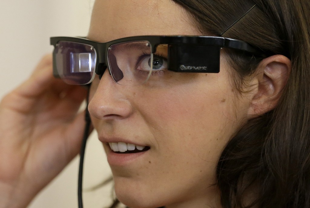 Claire Collins checks Optinvent ORA-S augmented reality glasses at a conference for the business of wearable technology in San Francisco on Monday.