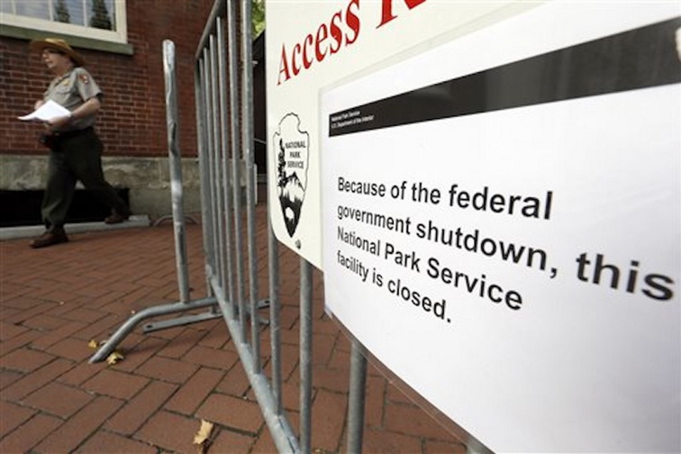 A National Park Service employee exits the courtyard of Independence Hall in view of a posted sign saying the facility is shut down at Independence National Historical Park on Tuesday in Philadelphia.