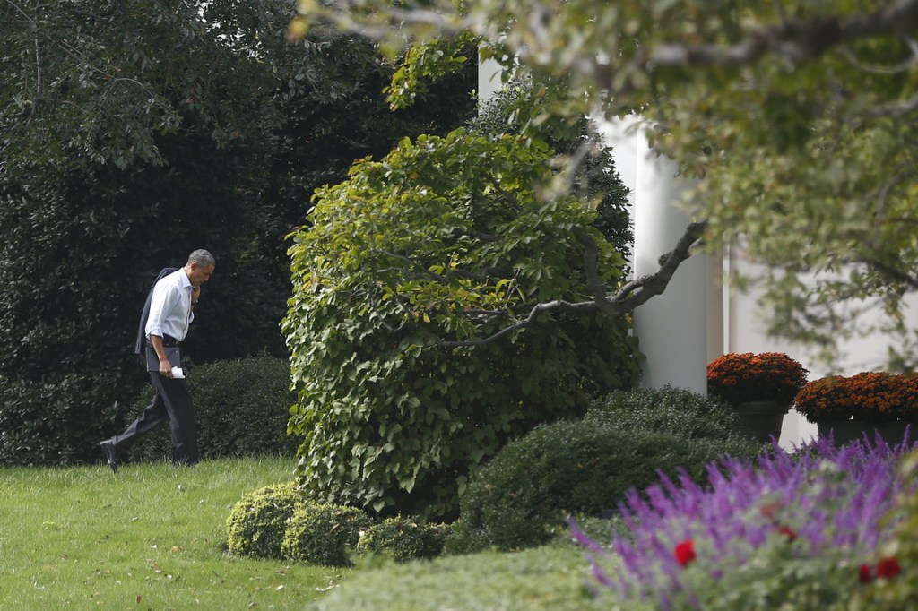 President Barack Obama walks back to the Oval Office after he visited Martha’s Table, which assists the poor and where furloughed federal employees are volunteering, in Washington on Monday. Speaking there Obama said that if Republicans can’t resolve the standoff over the debt ceiling and the partial government shutdown, “we stand a good chance of defaulting.”