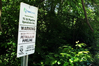 A sign for the Keystone tar sands pipeline stands by a bike path in Edwardsville, Ill., in 2010. The controversial South Portland Waterfront Protection Ordinance is aimed at forestalling the potential handling of tar sands in the city.