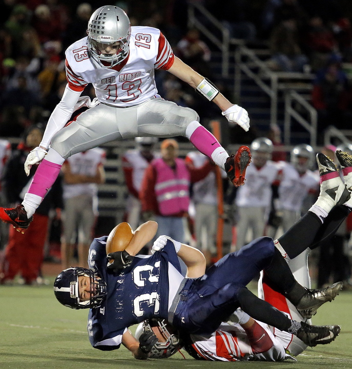 Justin Zukowski of Portland goes down as Hayden Owen of South Portland goes up Friday night during the Battle of the Bridge at Fitzpatrick Stadium. Zukowski rushed for 226 yards in a 38-14 victory.