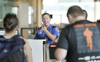 TSA employee Donna Castle calls travelers to the Jetport’s document check-in site as they prepare to go through security last month. The TSA has added Portland to the list of airports offering expedited screening.