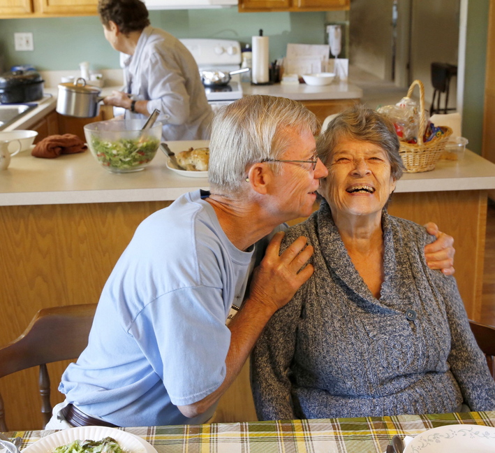 Bill Kelly, 64, gives roommate Jackie Kindl, 81, a hug at lunch in the house they share with three other seniors in Lombard, Ill.