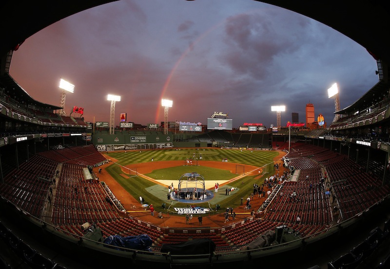 In this file image taken with a fisheye lens, Boston Red Sox players take batting practice as a rainbow appears in the sky above Fenway Park on Tuesday, Oct. 22, 2013, in Boston. An average ticket to Fenway Park for Game 6 on Wednesday has hit $2,374, making it the most expensive in history. MLB