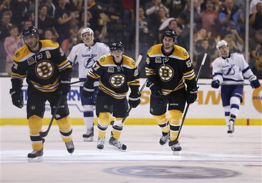 Boston Bruins' Patrice Bergeron, Torey Krug and Adam McQuaid skate to the bench in front of Tampa Bay Lightning's Richard Panik, of Slovakia, and Tyler Johnson after Bergeron's goal in the third period Thursday. The Bruins won 3-1.