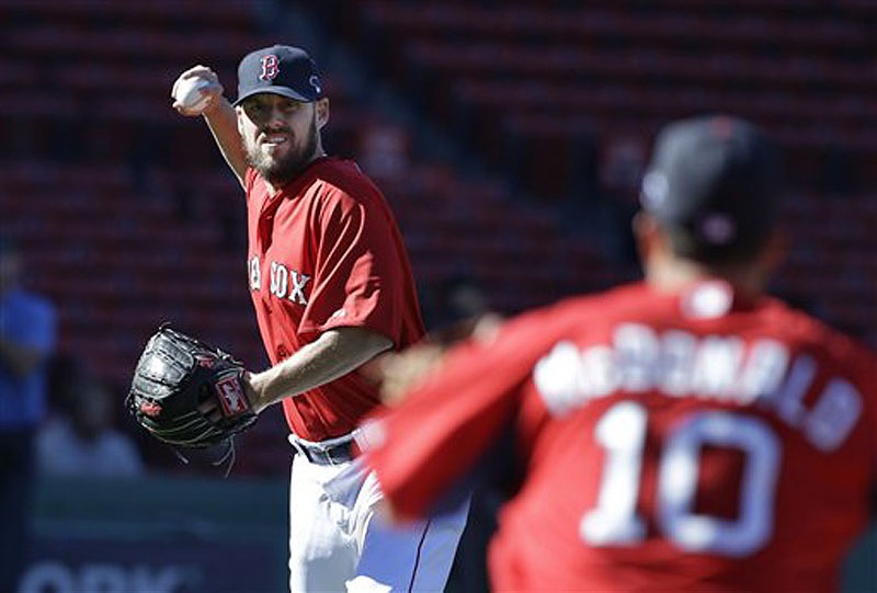 Boston Red Sox pitcher John Lackey winds up to throw to shortstop John McDonald (10) during a team workout at Fenway Park on Tuesday. The Red Sox host the Tampa Bay Rays in Game 1 of the AL divisional series on Friday.