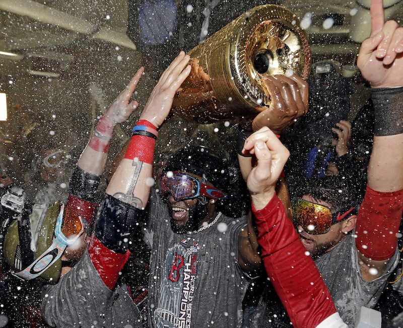 Boston Red Sox's David Ortiz holds up a large bottle of Champagne as he celebrates with teammates after Game 6 of baseball's World Series against the St. Louis Cardinals Thursday, Oct. 31, 2013, in Boston. The Red Sox won 6-1 to win the series. Ortiz was names the series MVP.