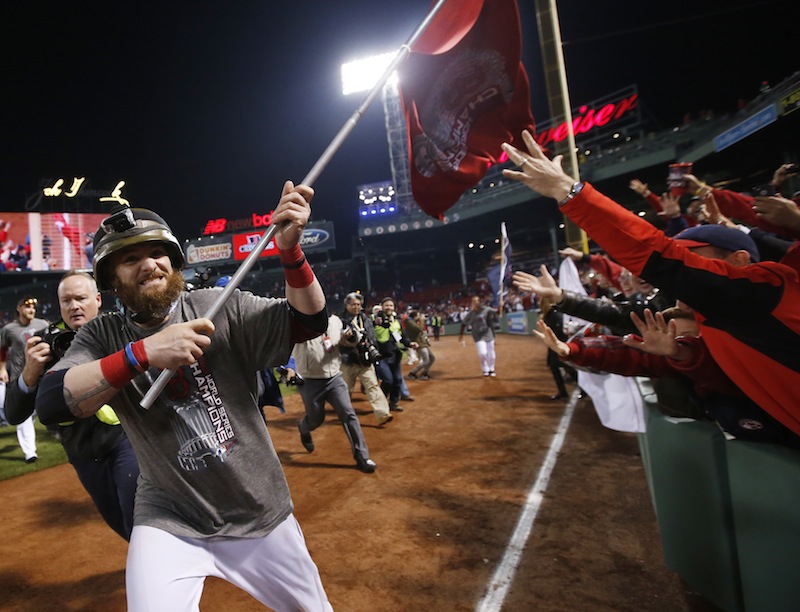 Boston Red Sox left fielder Jonny Gomes runs with a championship flag after defeating the St. Louis Cardinals in Game 6 of baseball's World Series Thursday, Oct. 31, 2013, in Boston. The Red Sox won 6-1 to win the series. MLB