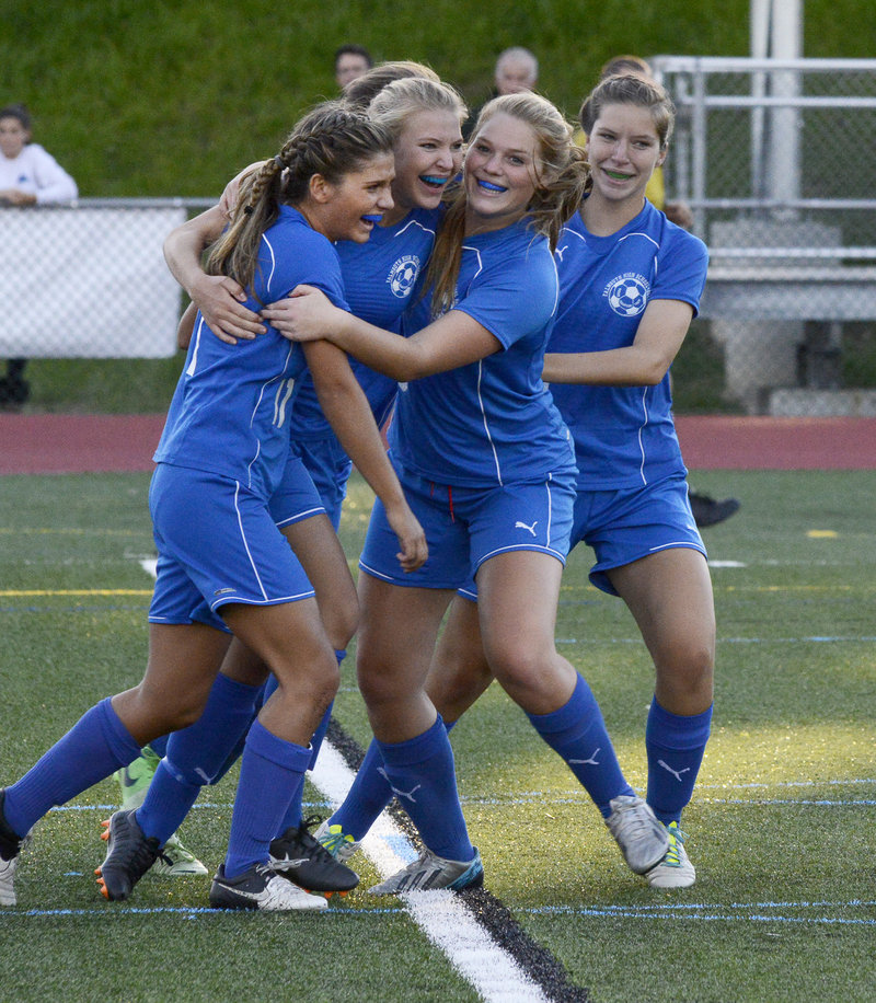 Taylor Russell, second from the left, gets congratuled by Mary Catherine Kowalsky, left, Laura Bauer and Brianna Russell after scoring in Monday’s girls’ soccer game against Yarmouth. Falmouth won, 3-1.