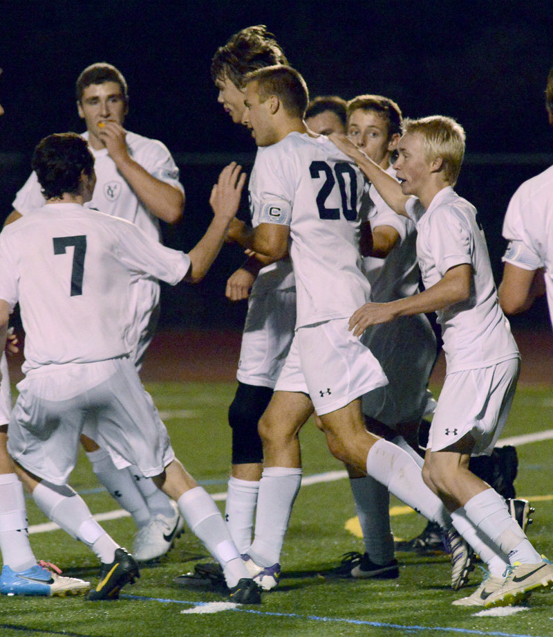 Yarmouth’s Chandler Smith (20) is congratulated by teammates after scoring the game-winning goal in Monday’s 1-0 win at home against Falmouth.