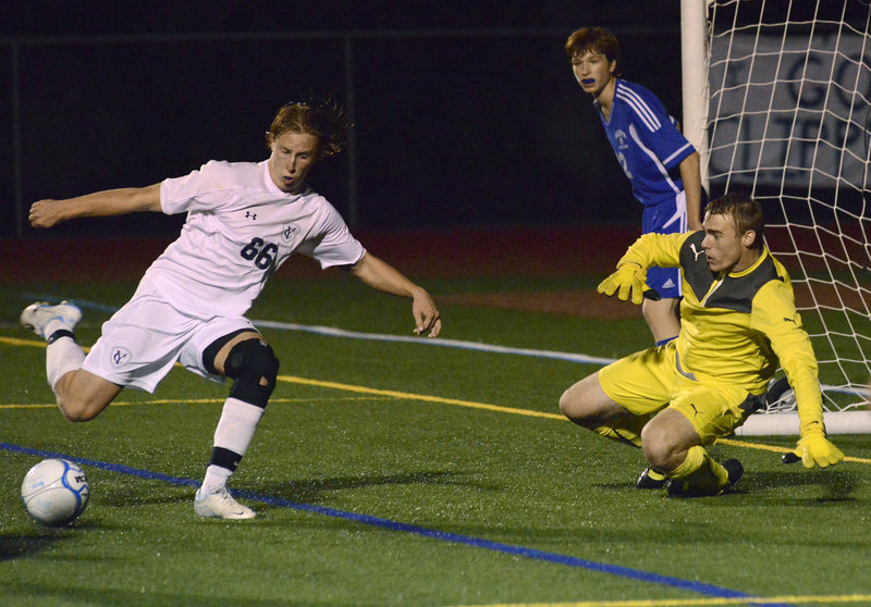 Yarmouth’s Wyatt Jackson prepares to hit a shot as Falmouth keeper Will D’Agostino moves to keep it wide on Monday night.