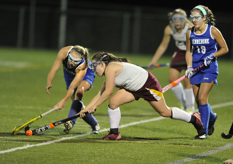 Kennebunk’s Olivia Sanford, left, battles with Cape Elizabeth’s Michaela Pinette for a loose ball on the artificial surface at Hannaford Field.