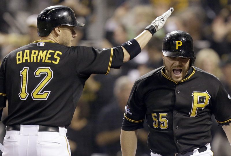 Russell Martin, right, of the Pittsburgh Pirates is welcomed by Clint Barmes after hitting his first of two homers Tuesday night in a 6-2 win against the Cincinnati Reds.