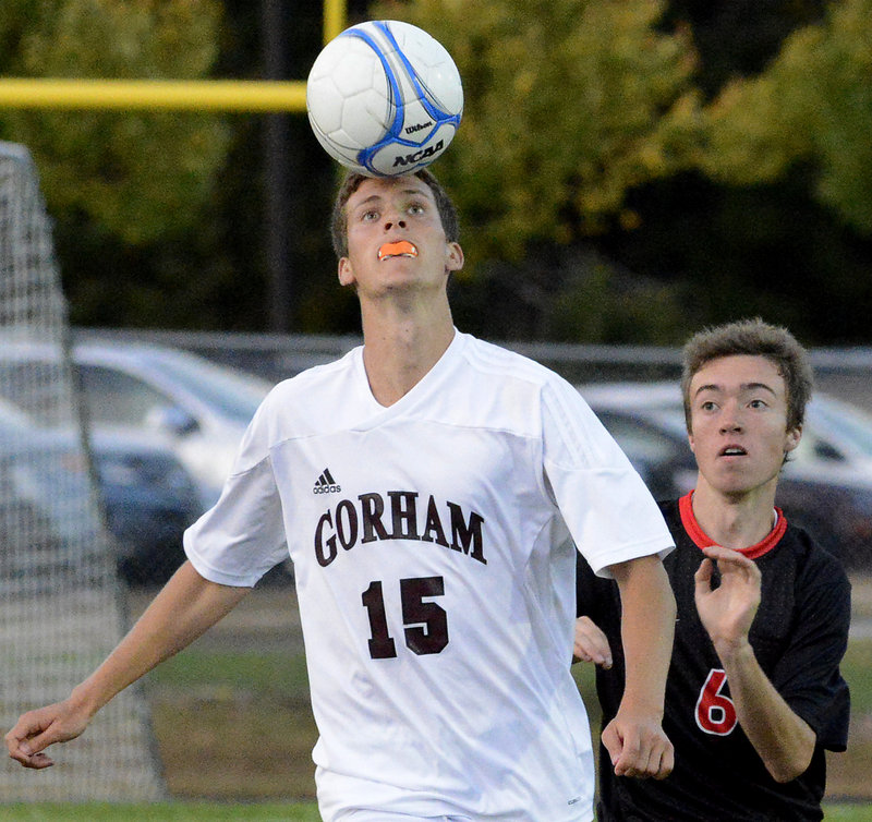 Austin Bell of Gorham holds his ground to head the ball in front of Christian Aguirre of Scarborough during their SMAA boys’ soccer game Thursday night. Wyatt Omsberg scored on a penalty kick in overtime to give Scarborough a 2-1 victory.