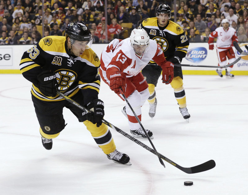 Bruins forward Brad Marchand keeps the puck away from Detroit’s Pavel Datsyuk during first-period action of Saturday night’s 4-1 victory in Boston. Marchand scored the winning goal in the second period.