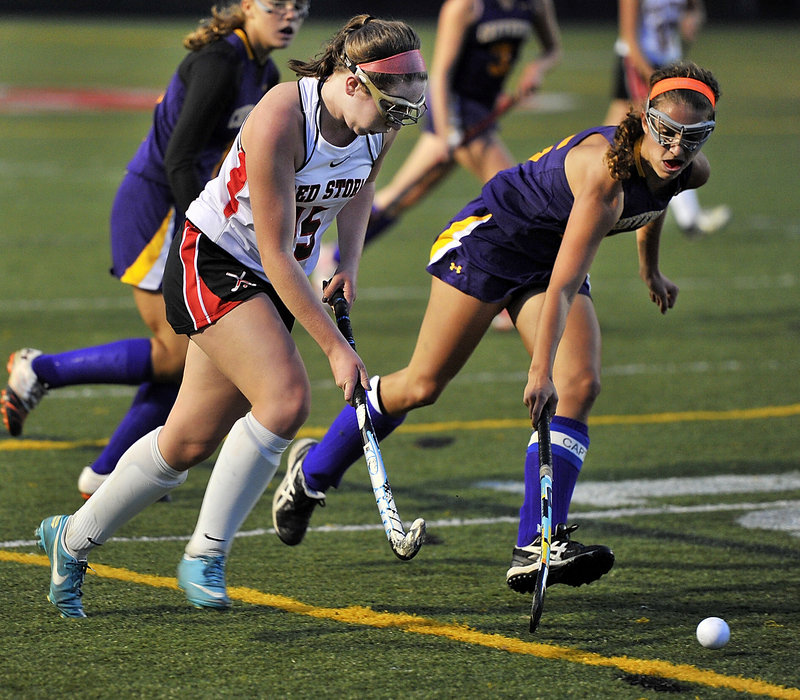 Abby Walker of Scarborough attempts to advance the ball against harassing defense by Elyse Caiazzo of Cheverus.