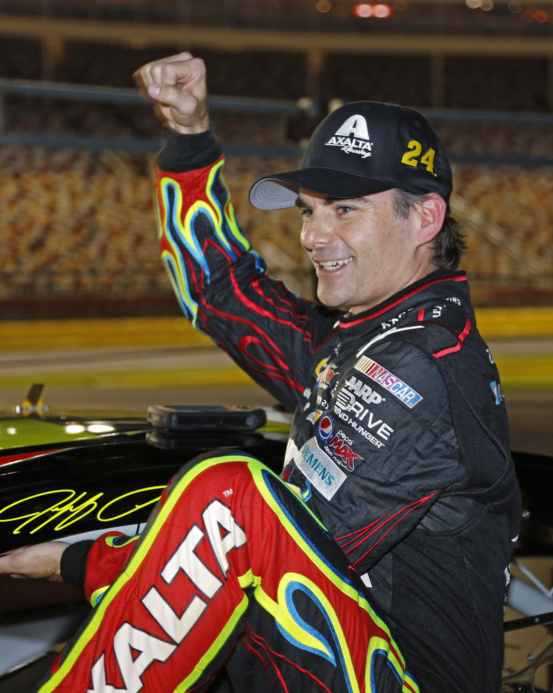 Jeff Gordon is clearly happy about his strong racing of late, as he exits his car Thursday in Charlotte, N.C., where he won the pole position for Saturday’s NASCAR Sprint Cup race.