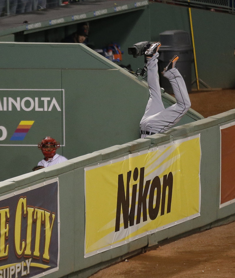 Tigers right fielder Torii Hunter flips over the wall into the Red Sox bullpen after his valiant bid to catch David Ortiz’s grand slam was just a little too late.