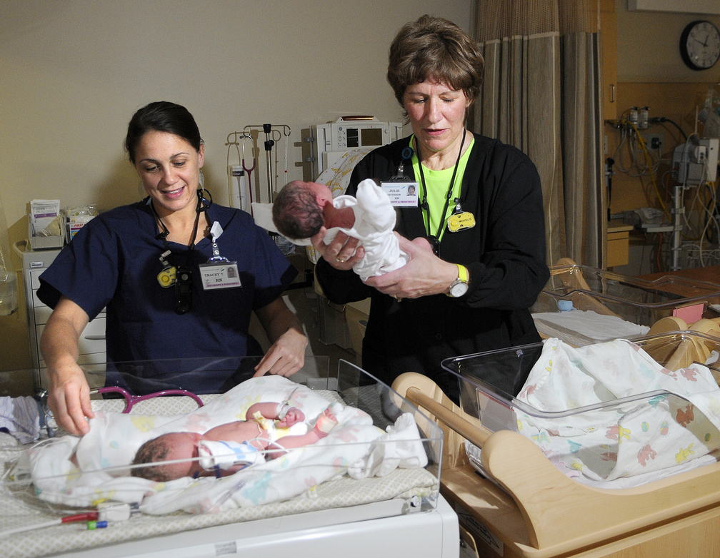 Nurse Julie Smithson, right, lifts day-old infant Hannah Veilleux away from her twin, Samuel, attended by nurse Tracey Thornton, at MaineGeneral’s new neonatal intensive care unit in Augusta on Sunday. The siblings, born five weeks early, are the first babies born at the new hospital.