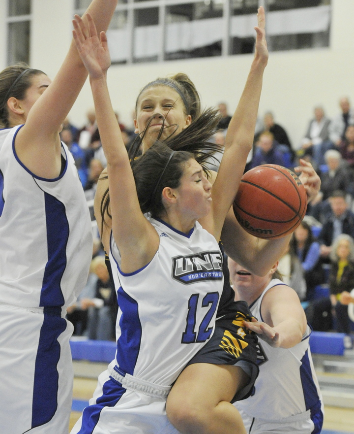 Sadie DiPierro of the University of New England fouls Abby Hasson of the University of Southern Maine while attempting to prevent a baseline drive Tuesday night. UNE came away with a 66-62 victory.