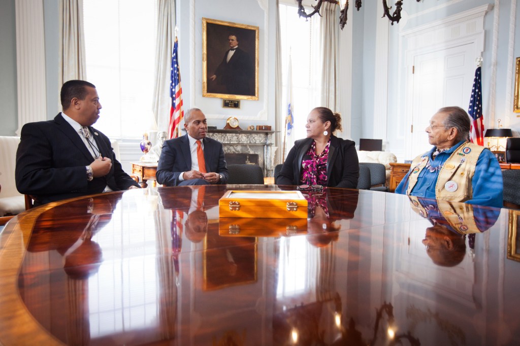 Mass. Gov. Deval Patrick sits with Mashpee Wampanoag Chairman Cedric Cromwell, far left, Vice Chairwoman Jesse Little Doe Baird and Chief Vernon Lopez, far right, on Friday at the Statehouse in Boston, where he signed a revised casino compact between the Mashpee Wampanoag tribe and the Commonwealth of Massachusetts. Tribal leaders, who hope to build a resort casino in Taunton, say they’re confident the revised casino compact will be approved by the federal Bureau of Indian Affairs.