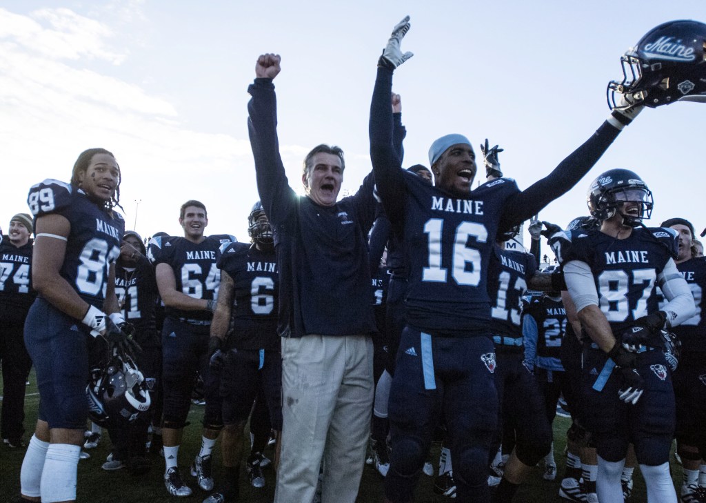 Coach Jack Cosgrove celebrates with his players after UMaine toppled Rhode Island 41-0 on Saturday to capture the CAA regular-season championship.