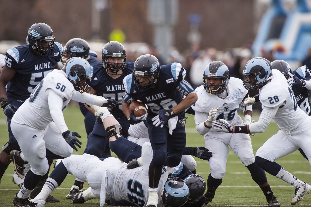 Maine running back Nigel Jones (26) is pursued by Rhode Island defender Shomari Watts, 50, and Adam Parker (46) in the first half of Saturday’s game in Orono.