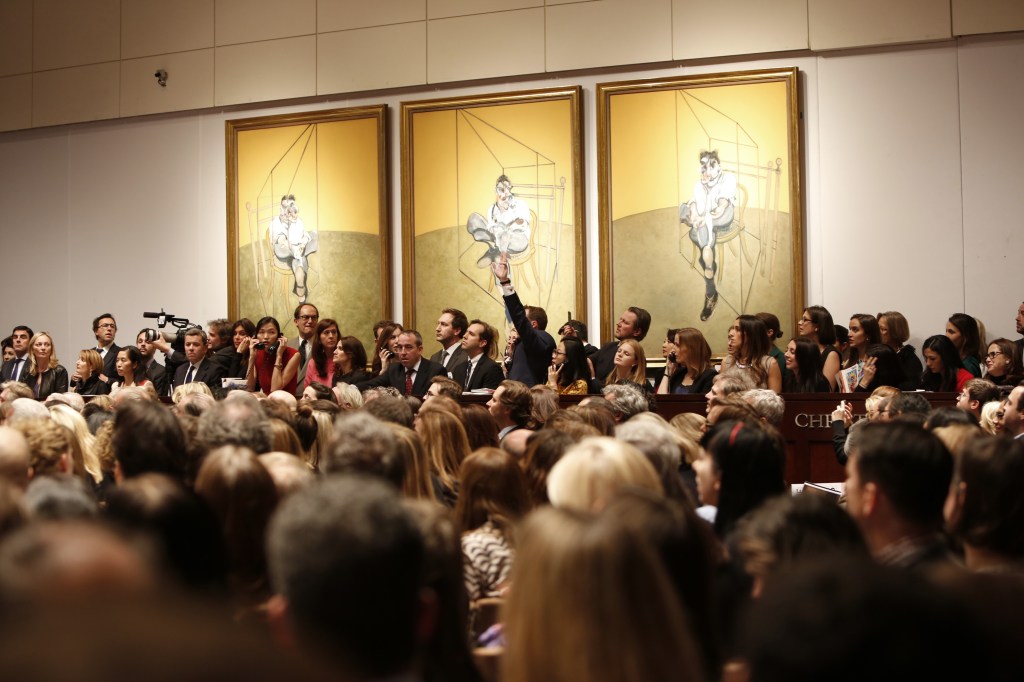 This photo provided by Christie’s shows the bidding during the auction for the 1969 painting by Francis Bacon, “Three Studies of Lucian Freud” in New York. The painting sold for $142 million.