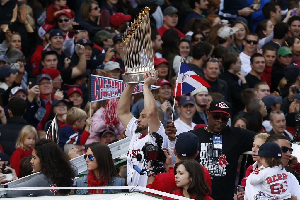 Boston’s Shane Victorino holds the World Series trophy on Duck Boat during a victory parade celebrating the team’s third World Series title since 2004 on Saturday in Boston.