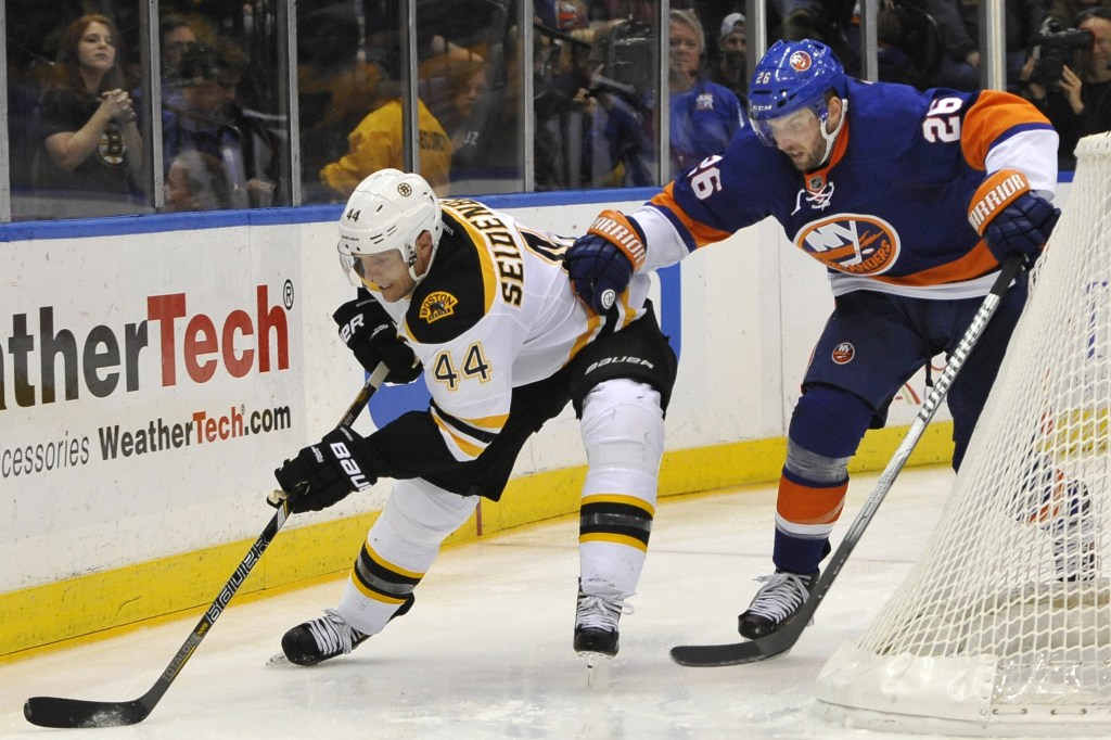 New York Islanders’ Thomas Vanek chases Boston Bruins’ Dennis Seidenberg around the boards in the third period of Saturday night’s game on Long Island.