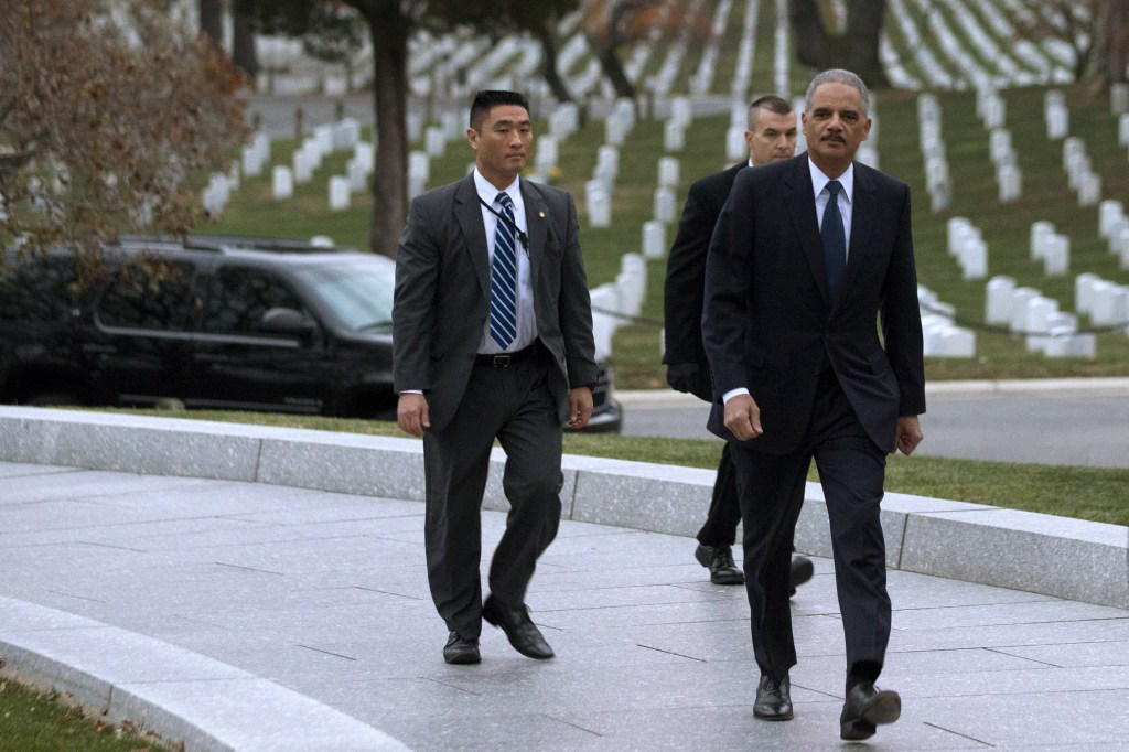 Attorney General Eric Holder, right, arrives to pay his respects at the grave of John F. Kennedy at Arlington National Cemetery on Friday, the 50th anniversary of Kennedy’s death. Holder has been visiting the grave since his youth, and would visit there with his mother before she passed away.