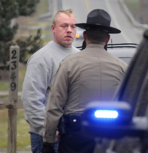 Courtney Shea is interviewed by police on Friday after he reported a body found outside an empty mobile home in Vassalboro. Shea is now charged with murder in Thomas Namer’s death.