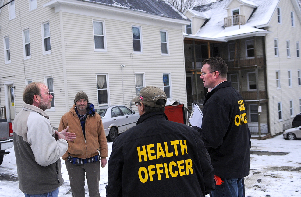 Property maintenance manager Jim Dutil speaks with city and state officials Tuesday after an inspection of the apartment building at 37 Washington St. in Augusta, owned by Jim Pepin. The city of Augusta got an administrative search warrant last week to enter and inspect several of Pepin’s multi-unit properties.