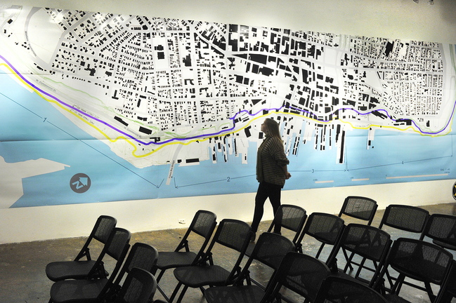 Orianna Bailey, an intern at Space, studies a large map of Portland that is part of the gallery’s exhibition “Waterfront Visions 2050.”