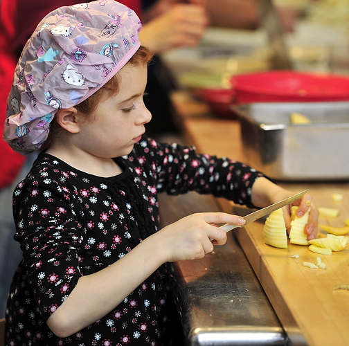Virginia March, 8, slices apples for the pies at the bake-off at St. Joseph’s College in Standish. The college food pantry was giving 225 families food baskets, each containing a hot pie.