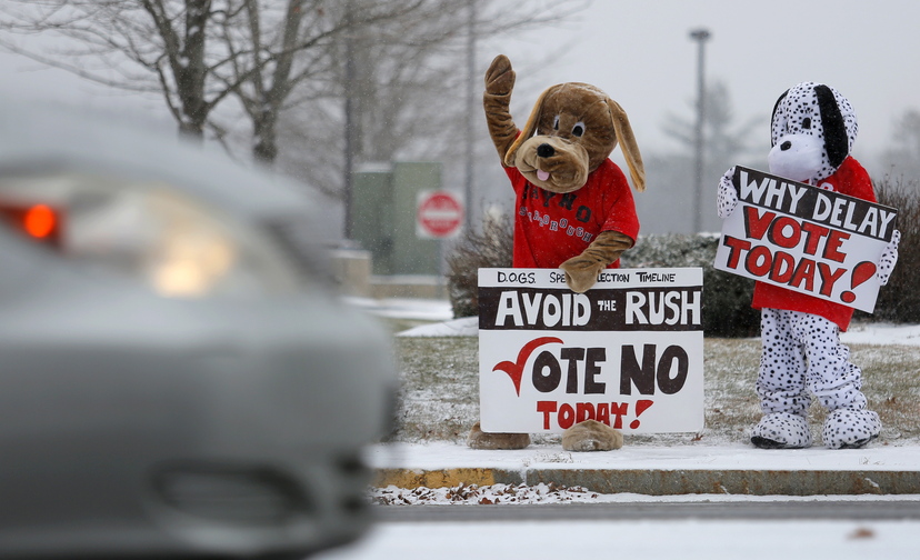 Katy Foley and Ellen O’Keefe of Scarborough dress up in dog costumes on Route 1 in Scarborough on Tuesday trying to drum up votes to repeal rules requiring dogs to be on leashes.