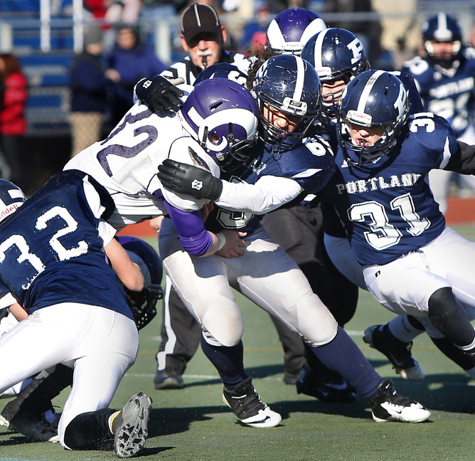 Dan Marzilli of Deering runs into a wall of Portland tacklers, including Justin Zukowski, left, Jeremiah Israel-Copeland, middle, and Joe Esposito while attempting to gain yards Thursday at Fitzpatrick Stadium during the 102nd annual Thanksgiving Day game. Portland earned a 47-6 victory.