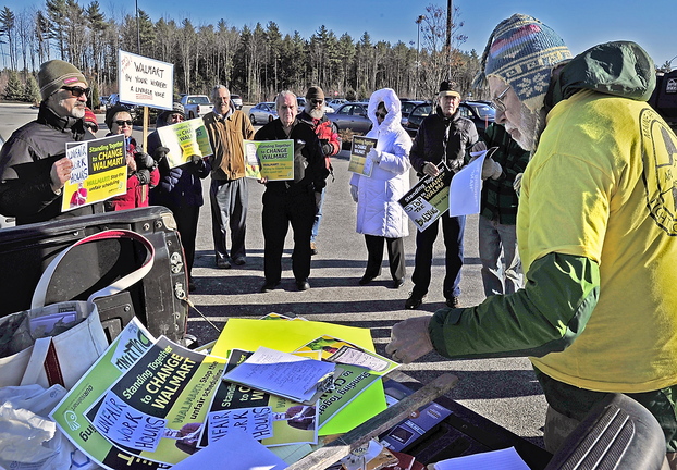 John Newton, right, a member of the executive board of the Maine AFL-CIO, hands out literature Friday to protesters and encourages them to enter the Walmart in Scarborough and talk to employees and customers. Demonstrations were held at about 1,500 Walmarts across the country.