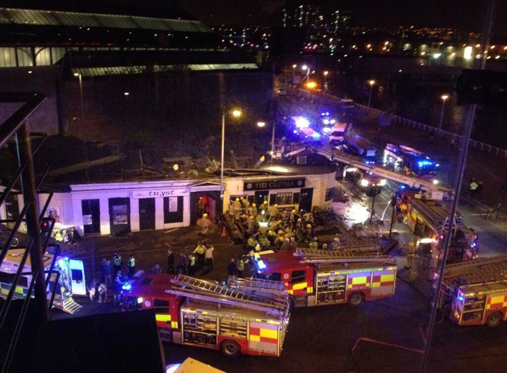 Police and Scottish Fire and Rescue services at the scene Saturday, Nov. 30, 2013, following the helicopter crash at the Clutha Bar in Glasgow, Scotland. Scottish emergency workers were sifting through wreckage Saturday for survivors of a police helicopter crash onto a crowded Glasgow pub that has killed at least one person and injured more than two dozen. The Clutha pub, near the banks of the River Clyde, was packed Friday night and a ska band was in full swing when the chopper slammed through the roof. The number of fatalities is expected to rise, officials said.
