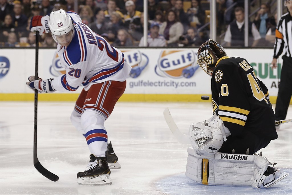 New York Rangers’ Chris Kreider (20) deflects a shot as Boston Bruins goalie Tuukka Rask of Finland defends during the first period of an NHL hockey game in Boston on Friday.