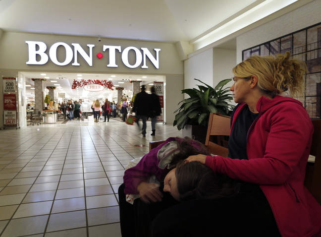 Zoe Sweet of Westbrook rests with her daughter, Luci, 10, as she waits for another daughter and her friend to finish shopping at Bon-Ton in South Portland. The Maine Mall and many of the surrounding stores opened their doors at around midnight to accomodate Black Friday shoppers.