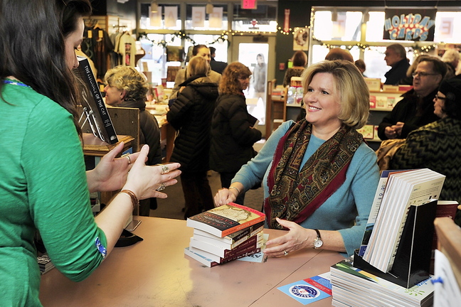 Jeanne Hulit, right, acting administrator of the Small Business Administration, buys books at Longfellow Books on Monument Square in Portland on Small Business Saturday.