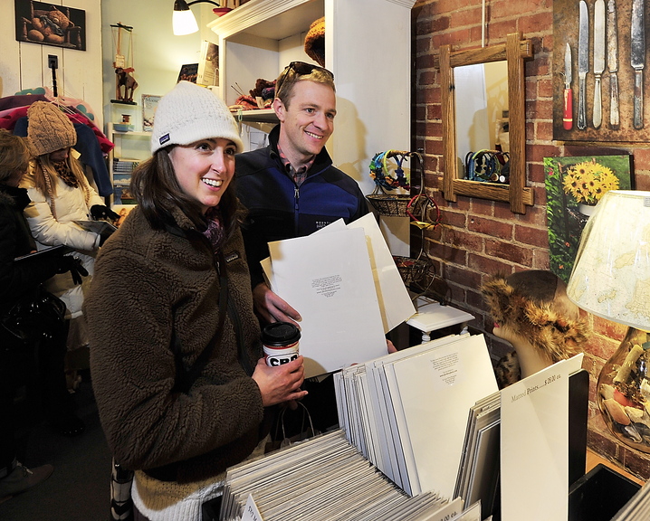 Julie and Toby Walch of Scarborough look at photographs at Lisa-Marie’s Made in Maine on Exchange Street in Portland on Saturday. “It’s what tourists want. They don’t want something made in China,” said Marie Stewart, the store manager.