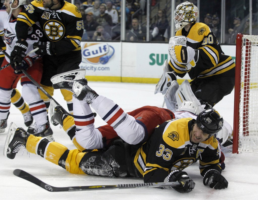 Boston Bruins defenseman Zdeno Chara goes to the ice as he also takes out Columbus Blue Jackets left wing Nick Foligno during the Bruins’ 3-1 win Saturday at Boston.