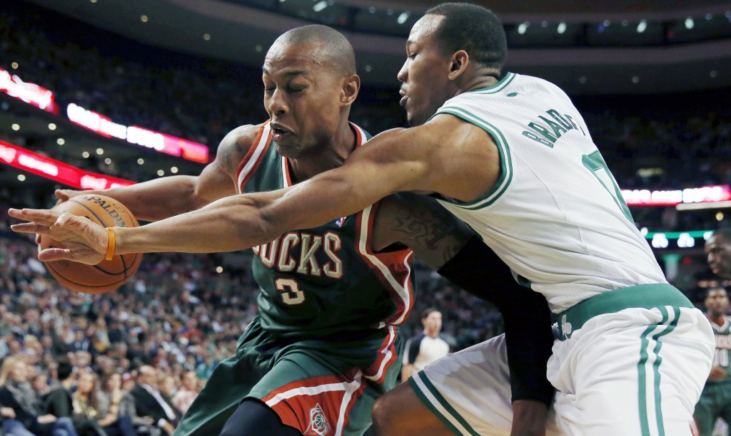 Boston’s Avery Bradley, right, tries to bat the ball away from Caron Butler of the Milwaukee Bucks in the first quarter of the Celtics’ home opener Friday night. Milwaukee took the lead in the final minute and earned a 105-98 victory.